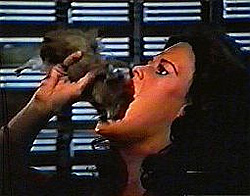 A woman swallows a large rodent whole.