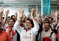 Aficionados del Sevilla cantan a su llegada al aeropuerto de Eindhoven (Holanda). (Efe/Chema Moya)