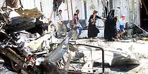 Civiles iraquíes en el lugar de la explosión de un coche bomba en Bagdad. (Efe)