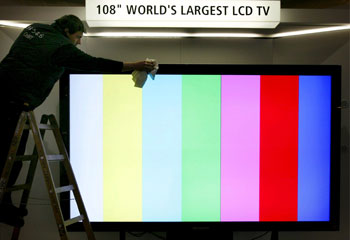Un hombre limpia la pantalla de LCD más grande del mundo en el CeBIT.