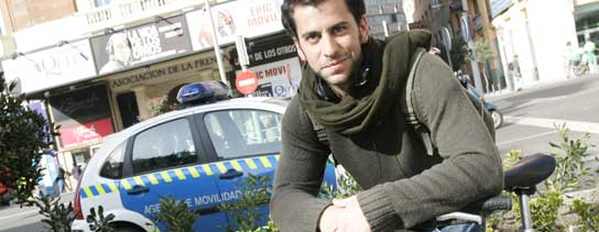 Federico, con su bici, delante de un coche de Policía. (Jorge Paris).