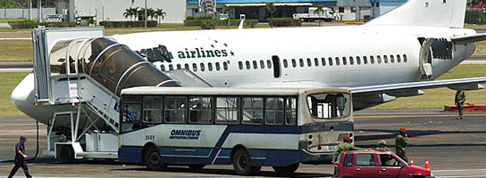 Vista del ómnibus secuestrado y del avión con el que intentaban hacerse unos reclutas armados. (Alejandro Ernesto / EFE).