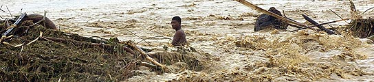 Un hombre arrastrado por la crecida del río Haina, a su paso por el municipio de Villa Altagracia (República Dominicana).