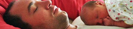 Un bebé duerme sobre el pecho de su padre.