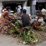 Un grupo de birmanos corta un árbol en la calle. (EFE)