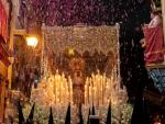 El paso de la Virgen de Nuestra Se&ntilde;ora de la Esperanza bajo una lluvia de p&eacute;talos arrojados desde los balcones de la calle Pureza en el sevillano barrio de Triana durante su recorrido procesional en la Madrug&aacute; de Sevilla.