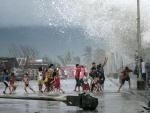 Olas de gran altura provocadas por el paso del tif&oacute;n Kammuri impactan sobre un grupo de ni&ntilde;os en Legazpi, Filipinas.