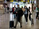 Viajeros procedentes de Italia portan mascarillas a su llegada al aeropuerto de Manises (Valencia).