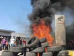 Trabajadores de Nissan queman neum&aacute;ticos como se&ntilde;al de protesta.
