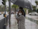 Dos personas sujetan un paraguas durante una tormenta en una imagen tomada durante el estado de alarma