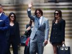 Johnny Depp saluda a su salida de los Reales Tribunales de Justicia, en Londres.