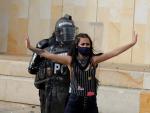 Una manifestante defiende a agentes policiales durante una protesta contra el Gobierno en Bogot&aacute;, Colombia.