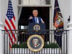 El presidente de EE UU, Donald Trump, saluda a sus simpatizantes desde un balc&oacute;n de la Casa Blanca mientras se quita la mascarilla.