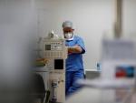 Un m&eacute;dico con mascarilla por el coronavirus reza antes de comenzar su turno en la UCI de un hospital de Sao Paulo, Brasil.