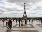 Varias personas pasean frente a la Torre Eiffel en Par&iacute;s.