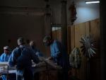 Enfermeros acomodan el cuerpo de un fallecido por covid-19 en una morgue improvisada en la iglesia de un hospital de S&atilde;o Leopoldo, en la regi&oacute;n metropolitana de Porto Alegre (Brasil).