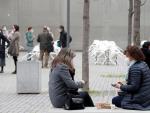 Varias personas consumen en la calle frente a unas terrazas cerradas en L'Hospitalet de Llobregat, en Barcelona.
