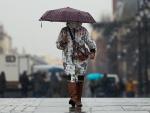 Una mujer se protege de la lluvia con un paraguas, en Madrid.