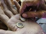 Una persona sujeta varios euros en su mano, en una imagen de archivo