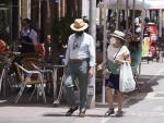Una pareja, con sombreros, se protegen del Sol durante el primer d&iacute;a de altas temperaturas en Sevilla.