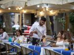 Un camarero atiende a una mesa en las Ramblas en Barcelona.