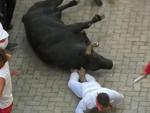 Un mozo ca&iacute;do en el suelo tras ser embestido por uno de los toros de Jandilla, en el sexto encierro de los Sanfermines 2022.