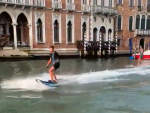 Dos j&oacute;venes haciendo esqu&iacute; n&aacute;utico en los canales de Venecia.