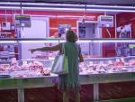 Una mujer hace la compra en la carnicer&iacute;a del Mercado de Pac&iacute;fico, en Madrid.