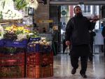 Un camarero pasa por un puesto de fruta y verdura en el Mercado Central de Valencia en una imagen de archivo.