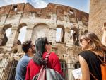 Turistas con un gu&iacute;a ense&ntilde;&aacute;ndole el Coliseo de Roma.