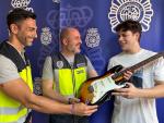 Agentes de la Polic&iacute;a Nacional entregan la guitarra sustra&iacute;da.