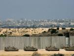 Al acecho. Un convoy de tanques tanques israel&iacute;es espera tras el muro de separaci&oacute;n las &oacute;rdenes para entrar en la franja de Gaza. El Gobierno israel&iacute; ha aprobado una escalada en las operaciones sobre territorios palestinos, que comenzaron tras el secuestro de un soldado israel&iacute;.