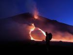 <strong>Anillo de fuego.</strong> Un turista pasa por delante del volc&aacute;n Etna en Sicilia. Su actividad volc&aacute;nica ha aumentado desde el pasado fin de semana.