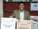 Correa sonr&iacute;e al emitir su voto, durante la primera vuelta electoral. (Guillermo Granja / REUTERS)