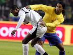 Ronaldinho (d), lucha por el bal&oacute;n con John Painstil, de la selecci&oacute;n de Ghana. (Efe)
