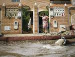 Una mujer, a la puerta de su casa en Almer&iacute;a, contempla los destrozos causados por el temporal.