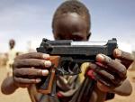 Un ni&ntilde;o sujeta la r&eacute;plica de una pistola en Darfur. (Stuart Price / Reuters).