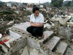 Una mujer permanece sentada sobre los escombros de lo que fue su casa en el barrio Bellavista de Santiago (Rep&uacute;blica Dominicana).