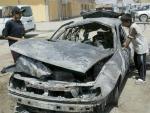 Dos ni&ntilde;os iraqu&iacute;es inspeccionan un coche destrozado en el lugar donde se han producido unos disturbios en Bagdad (Foto: Efe).