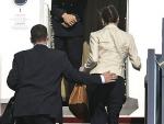 El personal de seguridad lleva a Bruni y al presidente franc&eacute;s al interior del avi&oacute;n.