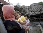 Una mujer observa su casa en ruinas tras el terremoto que ha asolado la isla de Java.