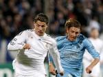 El delantero portugu&eacute;s del Real Madrid Cristiano Ronaldo (i) conduce el bal&oacute;n con la marca del argentino del Olympique Marsella Gabriel Heinze (d).