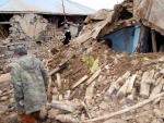 Varias personas caminan entre los escombros de una vivienda en Okcular, Turqu&iacute;a, despu&eacute;s del terremoto de seis grados.