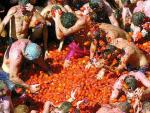 Un grupo de participantes en la tradicional fiesta de la Tomatina de Bu&ntilde;ol se lanzan unos a otros estos proyectiles rojos.