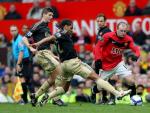 El delantero del Manchester United, Wayne Rooney, defiende el bal&oacute;n ante los jugadores del Liverpool, Steven Gerrard y Glen Johnson.