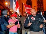 Varios polic&iacute;as intentan controlar a un grupo de sindicalistas en la puerta de la sede central de Correos de Valencia.