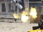 Rebeldes libios disparan una ametralladora montada en una camioneta, durante los combates que se libran en la ciudad de Sirte.