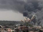 Columnas de humo se elevan sobre un barrio de Tr&iacute;poli, Libia, tras un ataque a&eacute;reo de la OTAN.