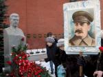 Una mujer con el retrato de Stalin deposita una rosa en la tumba del dictador sovi&eacute;tico.