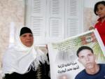 La madre de Mohamed Bouazizi, Manoubia, sostiene un cartel, junto con sus hijas Samia y Besma, de su hijo, cuya inmolaci&oacute;n prendi&oacute; la mecha de la 'Primavera &Aacute;rabe'.
